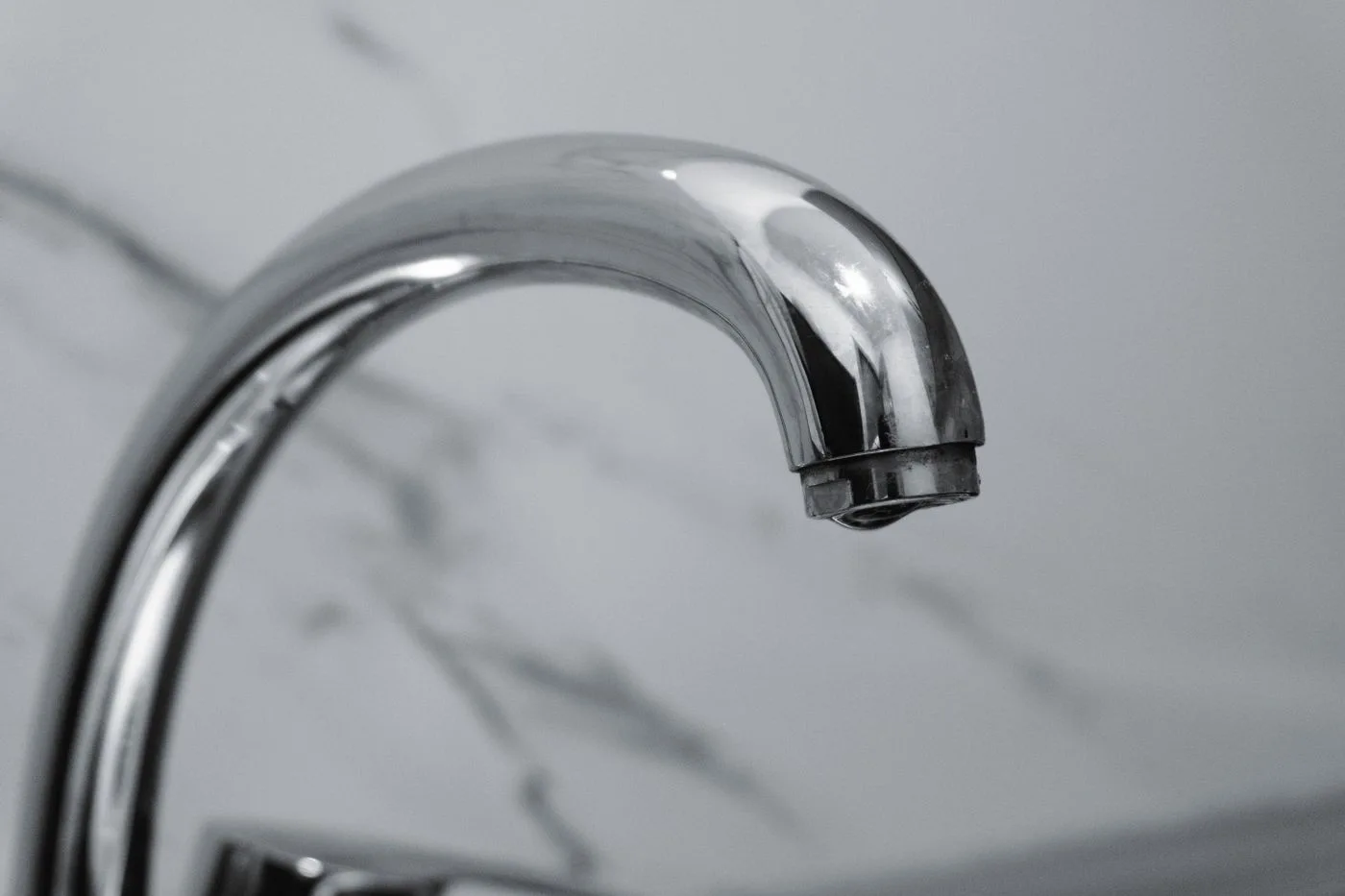 Chrome faucet with marble backsplash